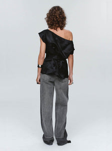 Back View of Person wearing a black one-shoulder top and gray pants on a white background